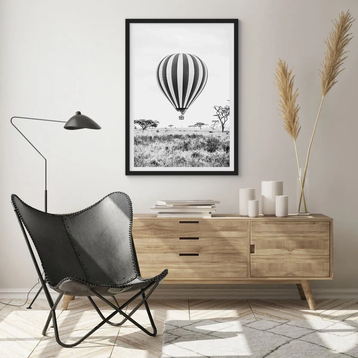 Poster în ramă neagră - Un balon cu aer cald plutind deasupra savanei în alb și negru. - 50x70cm - Peste savană - Decorațiune modernă pentru perete pentru living și dormitor ARTTOR