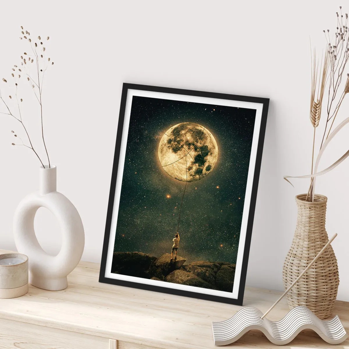 Poster în ramă neagră - O figură ținând luna pe o frânghie într-un peisaj înstelat. - 50x70cm - Cel care a furat Luna - Decorațiune modernă pentru perete pentru living și dormitor ARTTOR