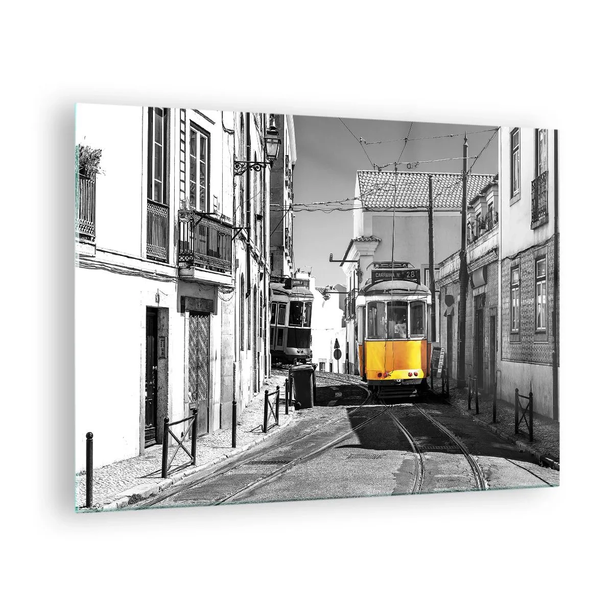 Tablou pe sticlă - Un tramvai galben pe o stradă alb-neagră dintr-un oraș european. - 70x50cm - Spiritul Lisabonei - Decorațiune modernă pentru perete pentru living și dormitor ARTTOR